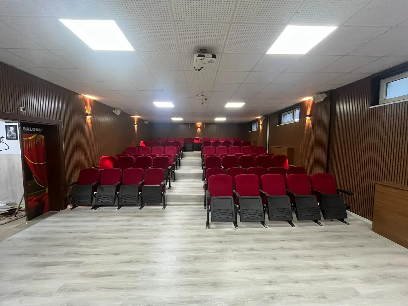 Lambri panel kaplama ve kırmızı koltuklu tamamlanmış konferans salonu